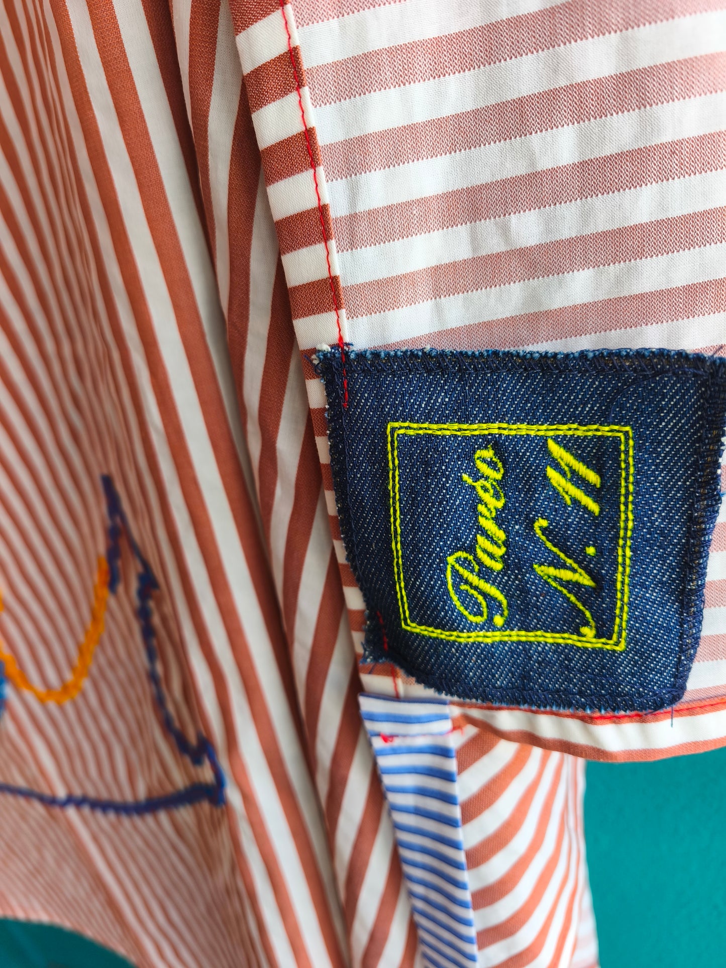 Paréo n.11 in cotone a righe con scritta "Summer"cucita in nastro multicolore ondulato.